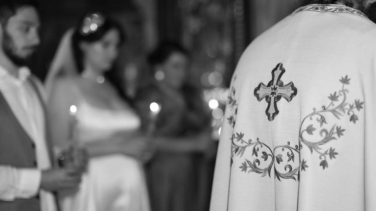 An orthodox wedding ceremony in church, focused on priest's ornate vestments.